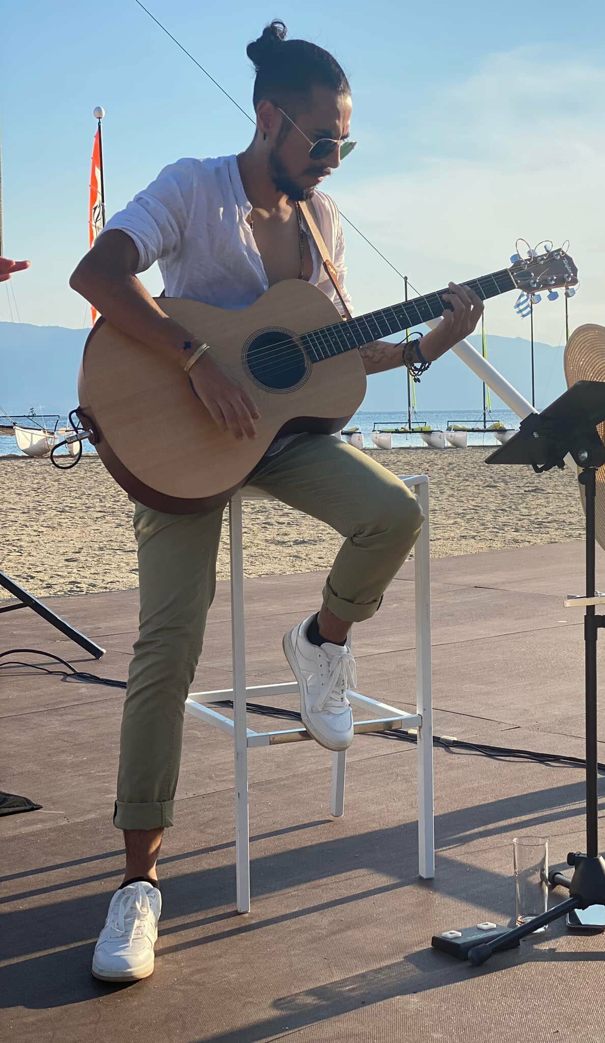 Guitariste, bord de mer, en pleine prestation musicale avec sa guitare acoustique